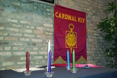 Cardinal Key banner and candles during a ceremony